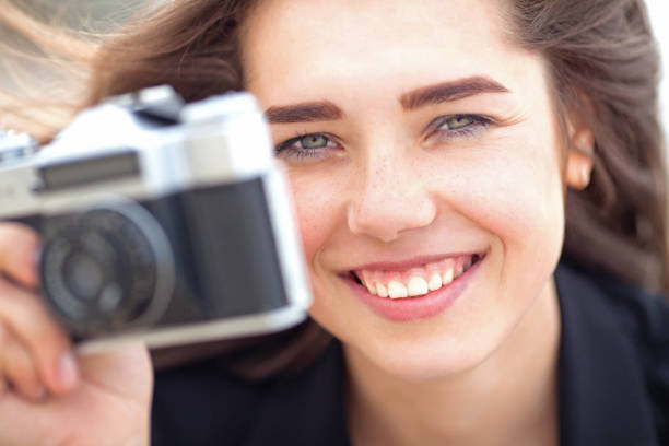 Beautiful young girl holding old film camera stock photo