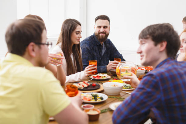 istock Group of happy people at festive table dinner party 836544504