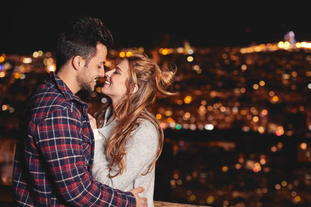 istock Smiling couple by illuminated city at night 836547302