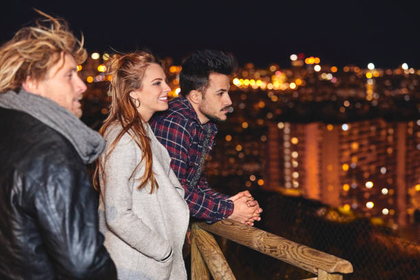 istock Smiling friends talking against illuminated city 836547360
