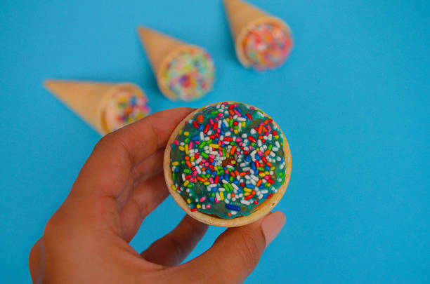 istock The girl holds the cornet in which is donut, blue background 836548250