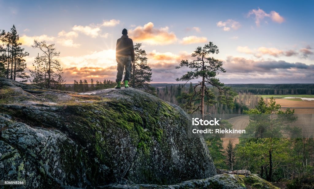 Hiker standing front of beautiful landscape at early morning Hiker standing front of beautiful landscape at early morning in Jaanankallio, Hyvinkää, Finland Finland Stock Photo