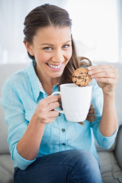 istock Smiling woman dunking cookie in coffee 836549274