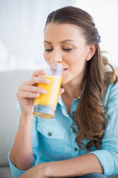 istock Happy woman drinking orange juice 836549330