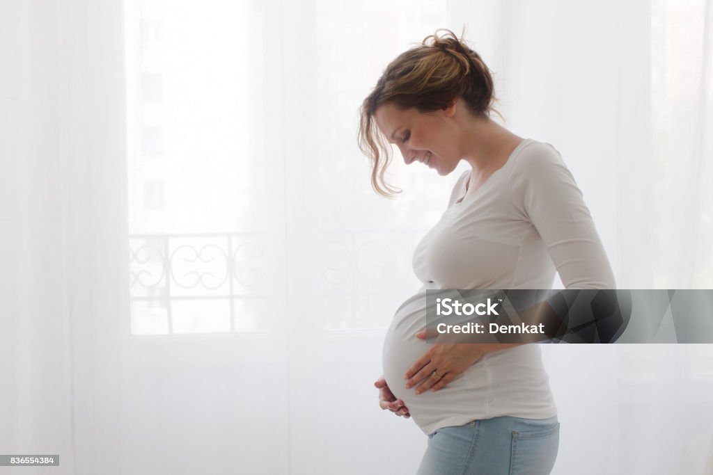 Pregnant woman touching belly - Foto de stock de Embarazada libre de derechos