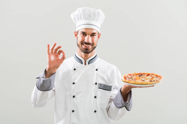 Chef holding pizza and showing ok sign. stock photo