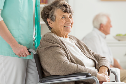 Happy senior woman in wheelchair smiling during free time