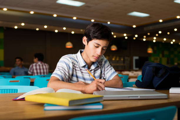 Male student sitting and writing stock photo