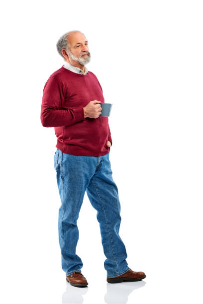 Senior man standing with coffee cup over white