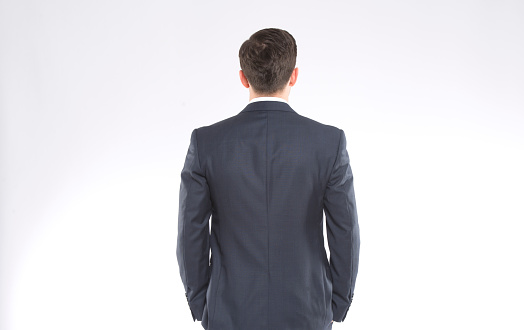 A businessman standing backwards wearing a suit