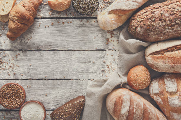 istock Bread bakery background. Brown and white wheat grain loaves comp 836563694