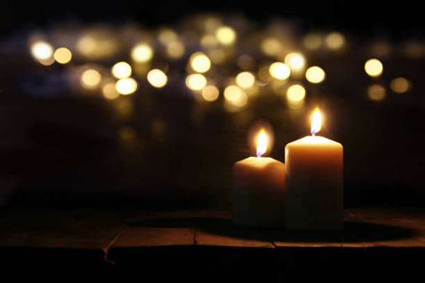 istock Burning candles over old wooden table with bokeh lights 836564576