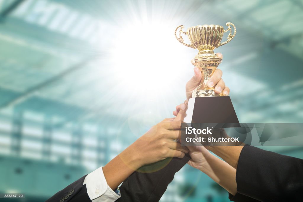 Award trophy Businessman team holding award trophy for show their victory. Achievement Stock Photo