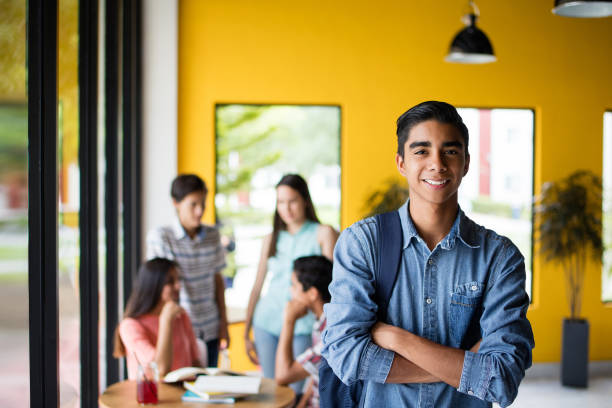 Male college student standing with students in background stock photo