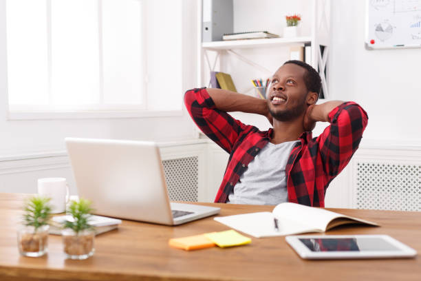 istock Relaxed black businessman with laptop in modern white office 836574180