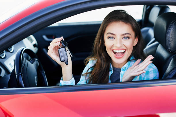 Happy woman in a new car stock photo