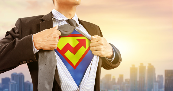 businessman in superhero costume with rising graph