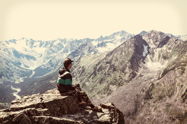 istock Man sit on sharp cliff above valley in rocky mountains park 836575218