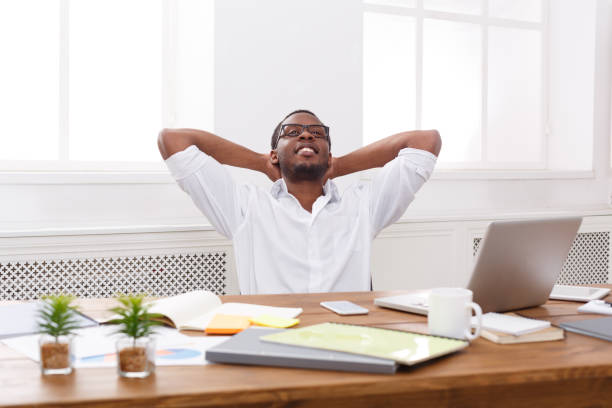 istock Relaxed black businessman with laptop in modern white office 836575472