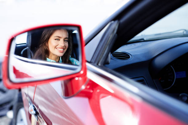 バックミラーを見ている女性 - owner women car rear view mirror ストックフォトと画像