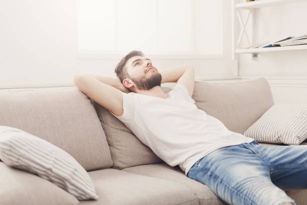 istock Handsome young man relaxing on the couch at home 836582480