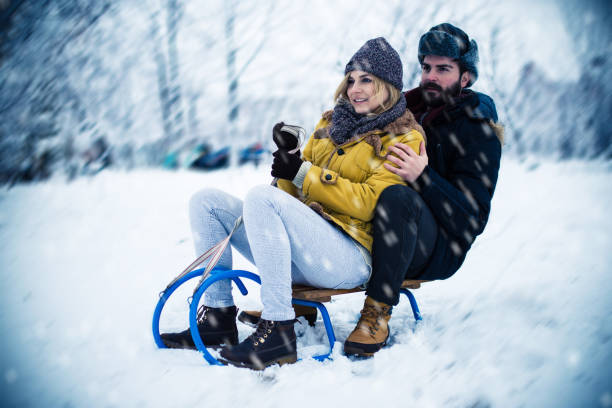 istock Young couple sledding together 836582516