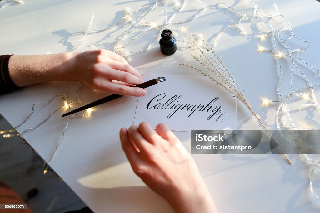 Mädchen schreibt Stift Brunnen kalligraphische Buchstaben, am Tisch sitzen - Lizenzfrei Kalligraphieren Stock-Foto