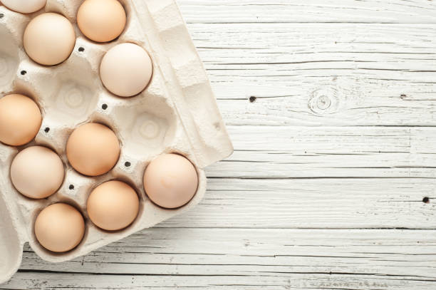 istock chicken eggs in cardboard box on white wooden background 836583078