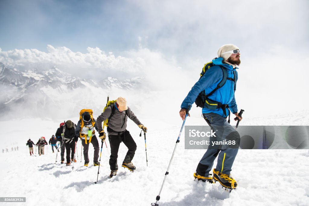 Eine Gruppe von Bergsteigern klettert an die Spitze der einen schneebedeckten Berg - Lizenzfrei Bergsteigen Stock-Foto