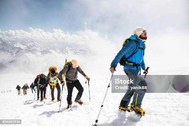 Eine Gruppe Von Bergsteigern Klettert An Die Spitze Der Einen Schneebedeckten Berg Stockfoto und mehr Bilder von Bergsteigen