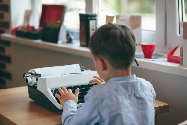 boy with typewriter - typewriter journalist newspaper obsolete imagens e fotografias de stock