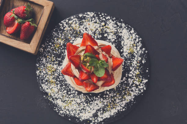 istock Anna Pavlova cake with strawberry on black background 836594998