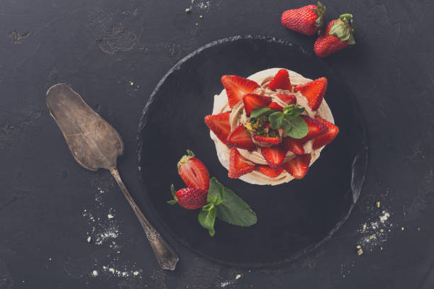 istock Anna Pavlova cake with strawberry on black background 836595118