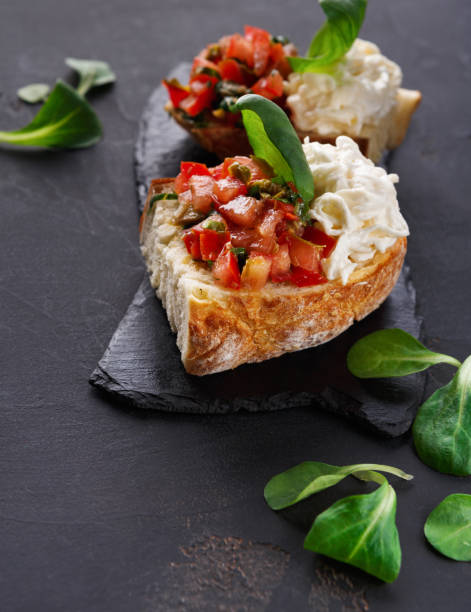 istock Bruschetta with cheese and vegetables on black background 836598178