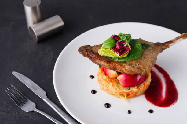 istock Restaurant meals. Duck confit with vegetables on black background 836598684
