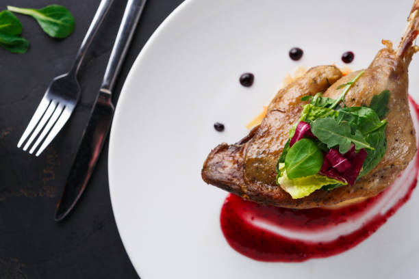 istock Restaurant meals. Duck confit with vegetables on black background 836598798
