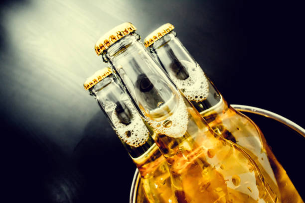 istock Beer in bottles with bubbles closeup on dark background 836602204