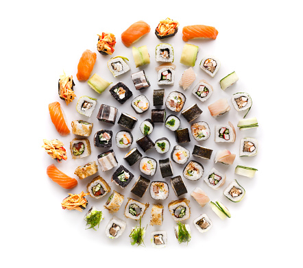 Big party sushi set isolated on white background. Japanese food delivery and take away. Fish and vegetable rolls, salmon nigiri and spicy gunkans, top view
