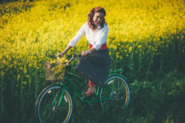 Young girl riding her green retro hipster bike