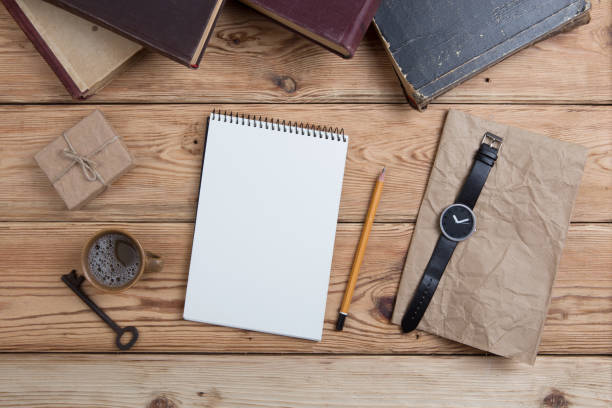 istock Top view on wooden desktop with books, keys, watch, notepad and gift box 836610872