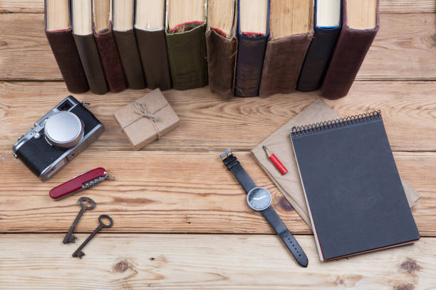 istock Top view on wooden desktop with books, camera, watch and gift box 836611808