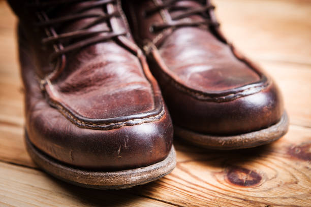 istock Brown leather boots on wooden background 836617980