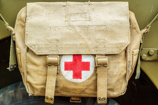 Aalten, The Netherlands - June 23, 2017: Red cross medical aid symbol on a vintage jute army bag on a local country fair in Aalten, The Netherlands