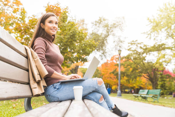 istock Woman with computer at park in autumn 836626648