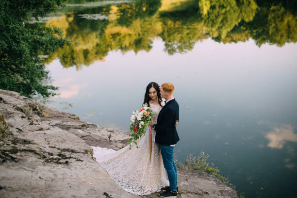 istock Happy newlyweds standing on the river bank 836638588