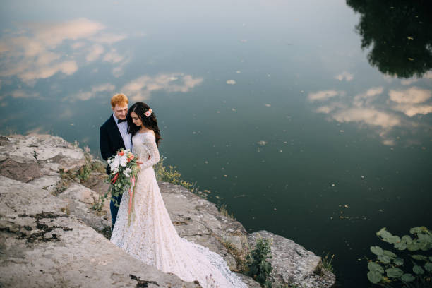 istock Happy newlyweds standing on the river bank 836641438