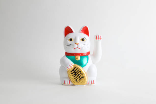 Maneki-neko white a Maneki-neko plastic cat, Symbolizing luck and wealth, on a white background maneki neko stock pictures, royalty-free photos & images