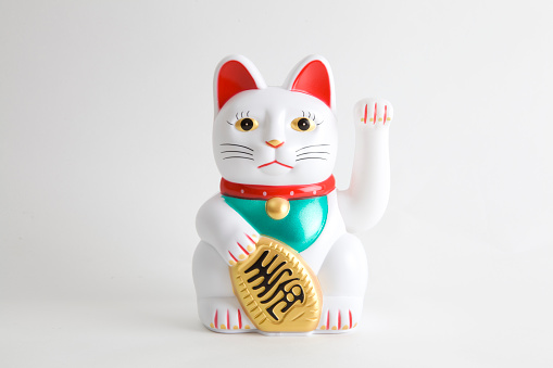 a Maneki-neko plastic cat, Symbolizing luck and wealth, on a white background