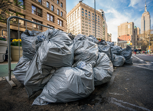 Rubbish bags piled up on a street in Midtown Manhattan, for collection by a truck.