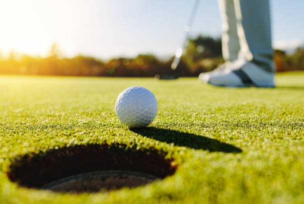 golfprofessional brengen bal - putten stockfoto's en -beelden